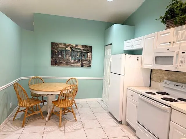 a view of a kitchen with fridge and wooden floor