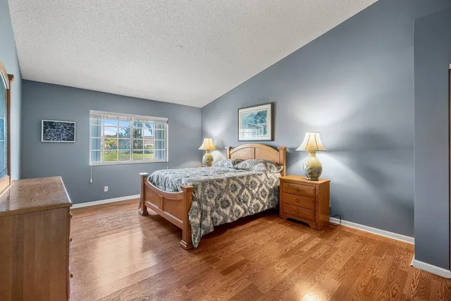 a bedroom with a bed and a lamp on desk
