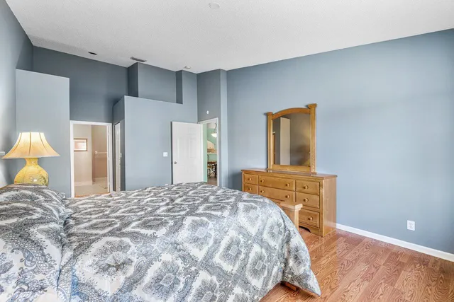 a bedroom with a bed and a dresser with mirror