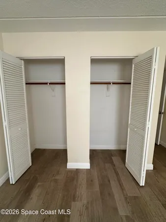 an empty room with wooden floor and a sink