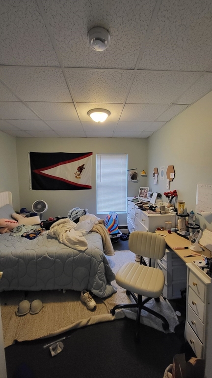 162 Riverside Street, Unit 2 Lowell, MA 01854 - Photo 11 of 12 a bedroom with a bed and a table