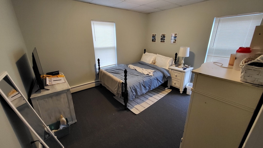 162 Riverside Street, Unit 2 Lowell, MA 01854 - Photo 9 of 12 a bedroom with a bed and a flat screen tv