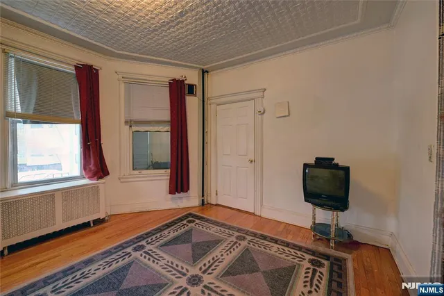 a view of a livingroom with a piano and wooden floor