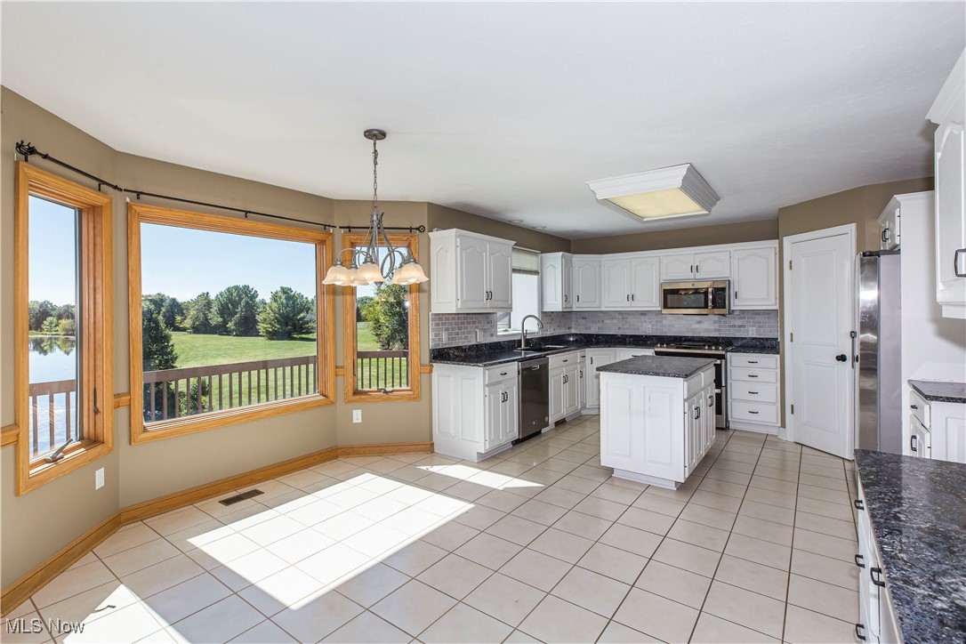 1570 Reimer Road Wadsworth, OH 44281 - Photo 10 of 48 Kitchen featuring light tile patterned floors, a chandelier, backsplash, white cabinetry, and decorative light fixtures