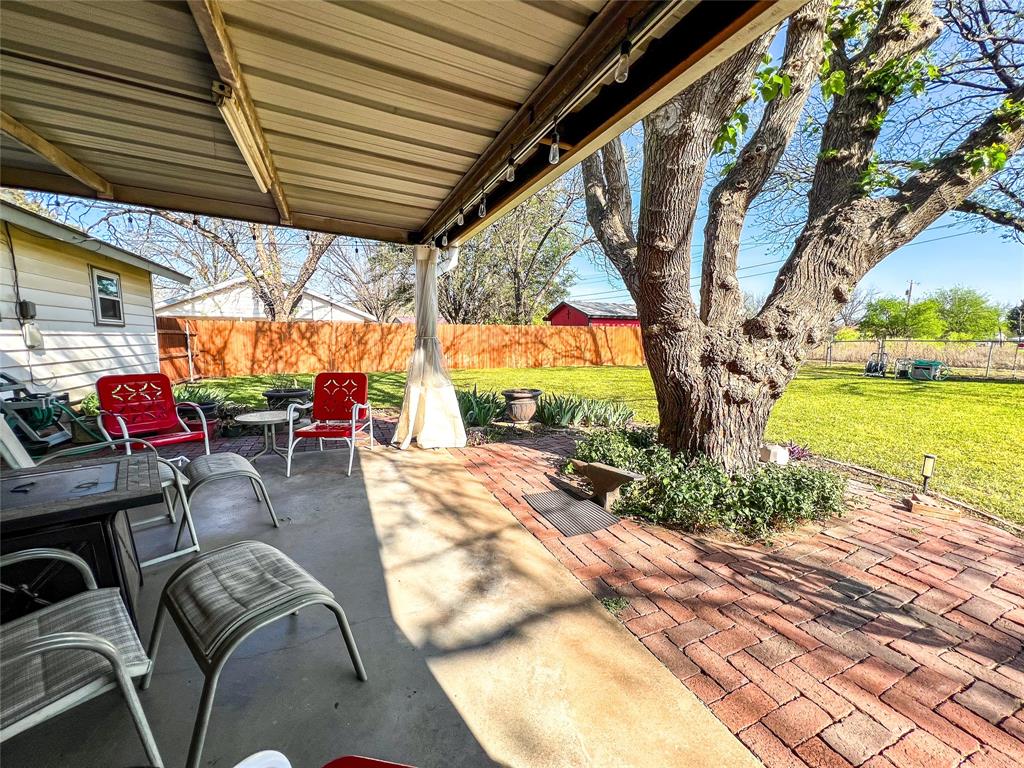 1009 North 7th Street Haskell, TX 79521 - Photo 20 of 26 a view of a patio with table and chairs potted plants and a large tree