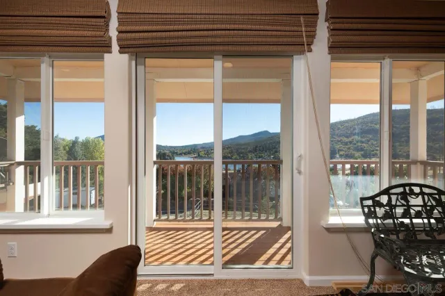 a view of a room with a large window and wooden floor