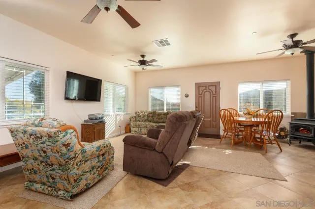 a living room with furniture a large window and a flat screen tv