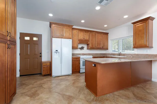 a kitchen with stainless steel appliances granite countertop a refrigerator and a sink