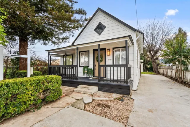a view of a house with a small yard and wooden fence