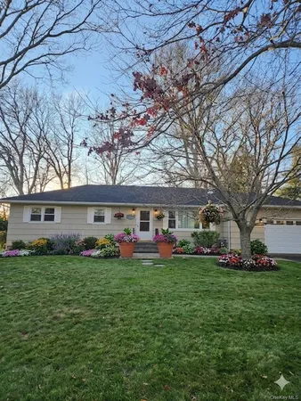 a view of a house with a big yard and large trees