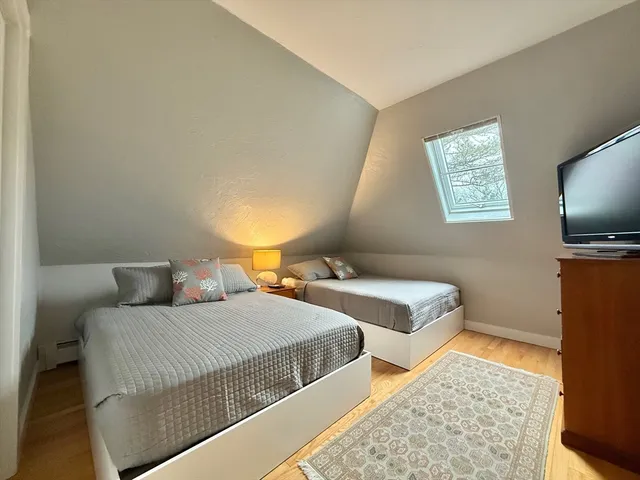 a bedroom with two beds and a flat screen tv