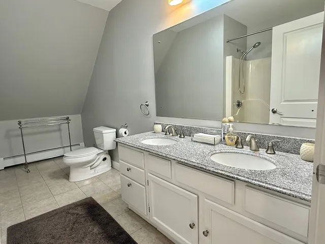 a bathroom with a granite countertop toilet sink and mirror