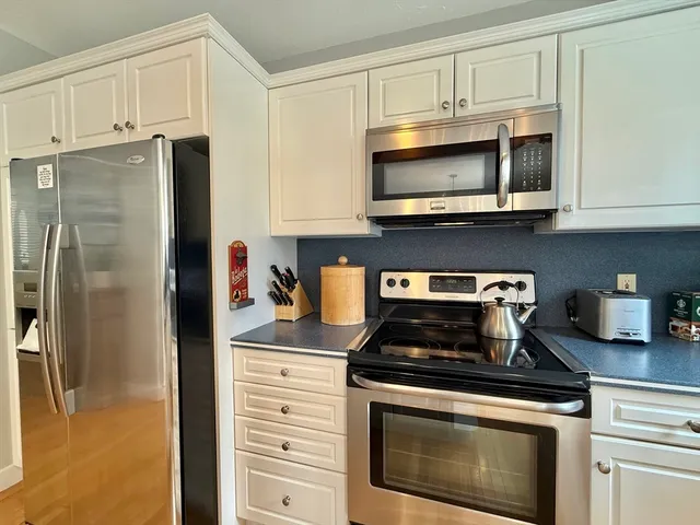 a kitchen with stainless steel appliances granite countertop a stove microwave and refrigerator