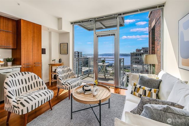 a living room with furniture kitchen view and a window