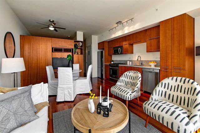 a kitchen with stainless steel appliances kitchen island granite countertop a table chairs in it and wooden floors