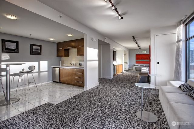 a dining hall with stainless steel appliances granite countertop a kitchen island a sink dishwasher and a refrigerator