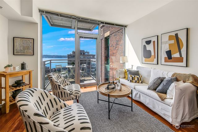 a living room with furniture a lamp and a large window