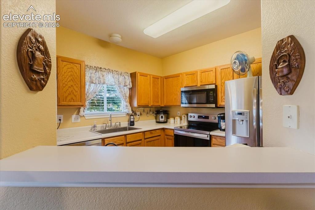4008 Riviera Grove, Unit 103 Colorado Springs, CO 80922 - Photo 9 of 39 The open pass-through keeps the cook in all the action!