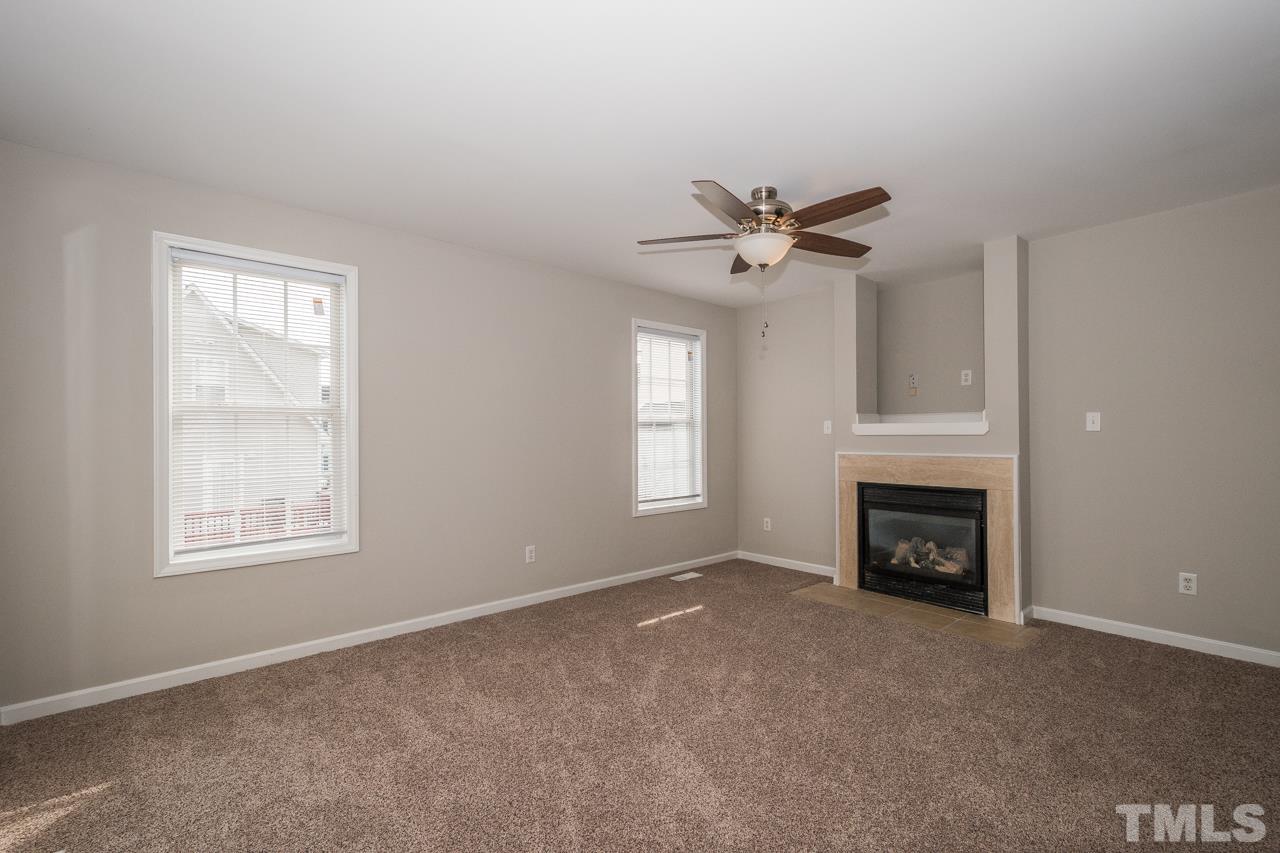 4424 Windstorm Way Raleigh, NC 27616 - Photo 8 of 14 an empty room with fireplace and windows