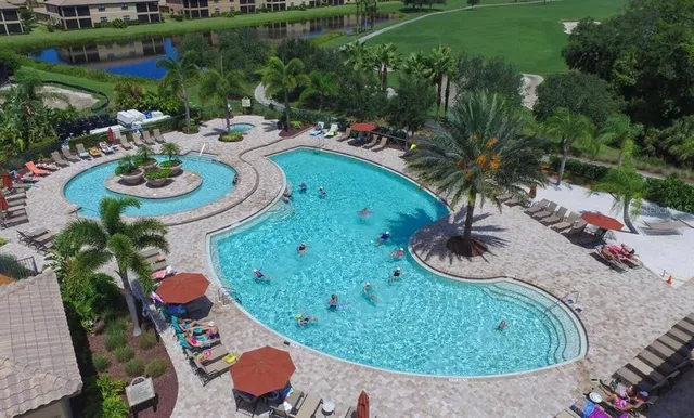 a view of a backyard with couches under an umbrella