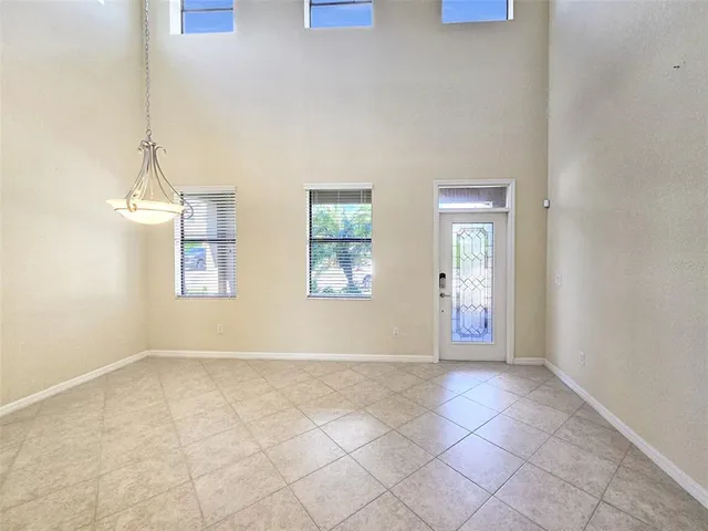 a view of an empty room with a ceiling fan and window