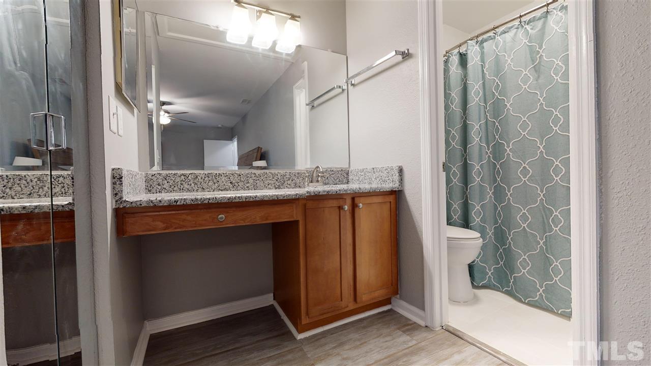 2453 Condor Court, Unit 2453 Raleigh, NC 27615 - Photo 17 of 26 a bathroom with a granite countertop sink and a mirror