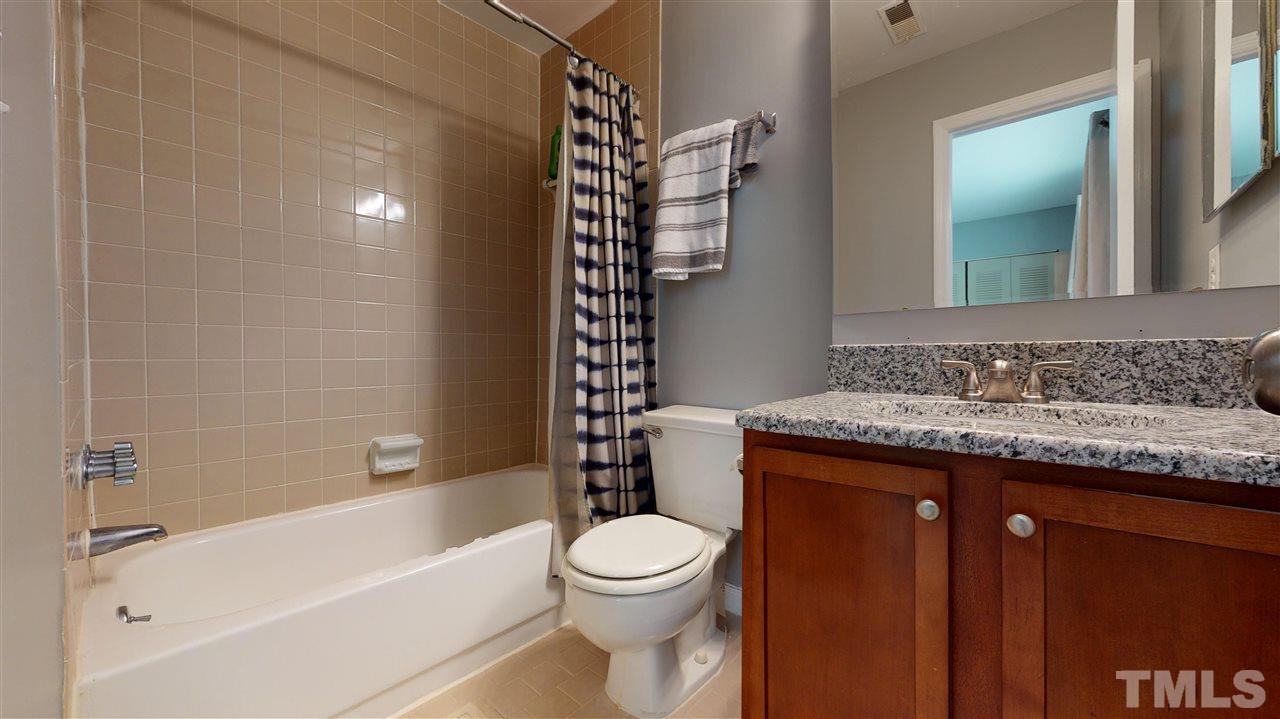 2453 Condor Court, Unit 2453 Raleigh, NC 27615 - Photo 20 of 26 a bathroom with a granite countertop sink toilet and shower