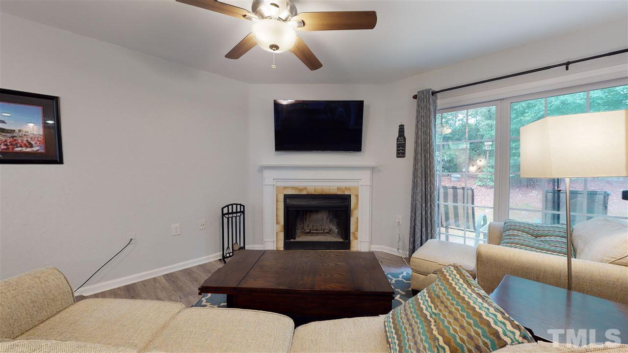 2453 Condor Court, Unit 2453 Raleigh, NC 27615 - Photo 5 of 26 a living room with furniture a flat screen tv and a fireplace