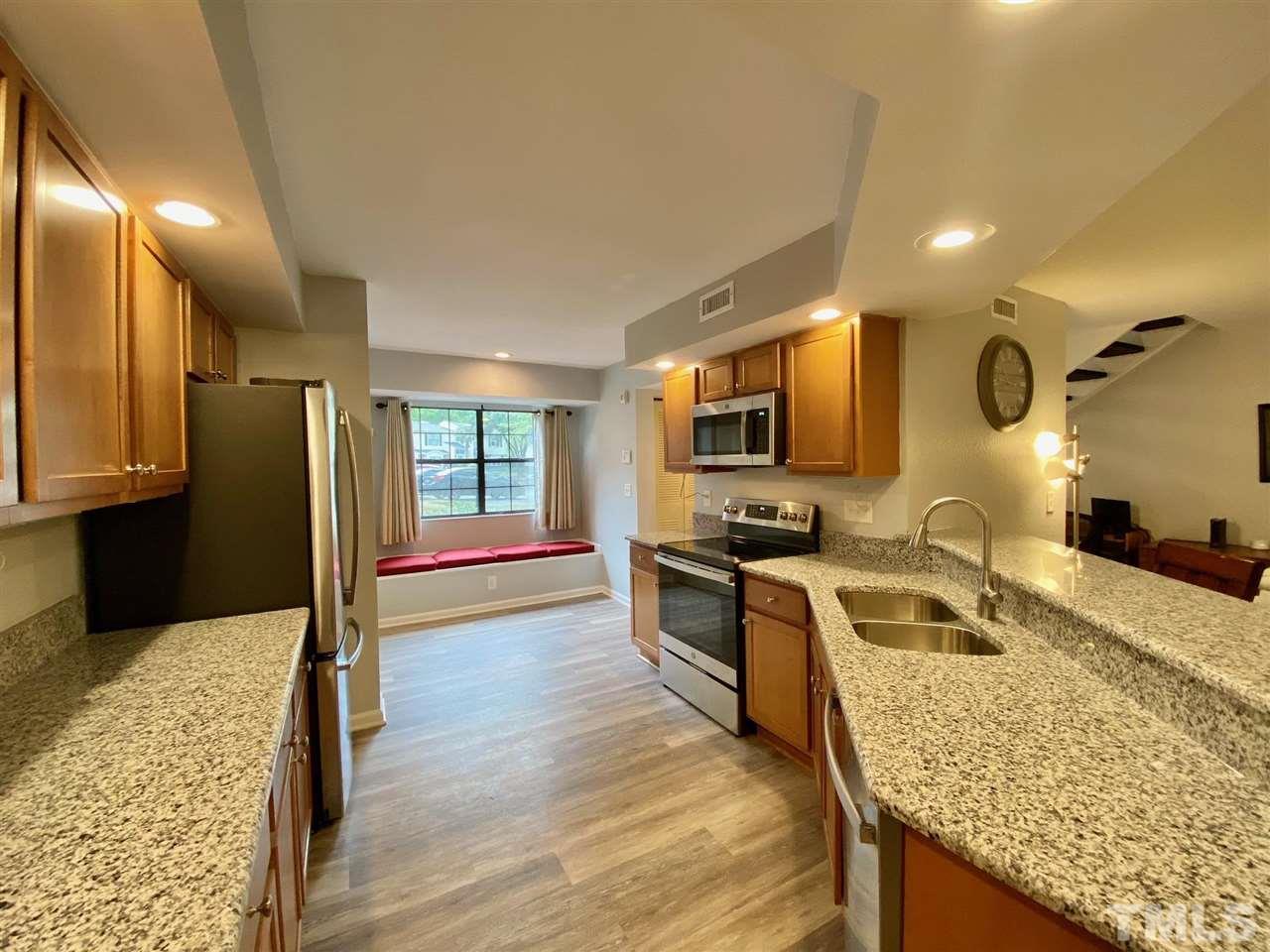 2453 Condor Court, Unit 2453 Raleigh, NC 27615 - Photo 7 of 26 a kitchen with stainless steel appliances granite countertop sink stove refrigerator and cabinets