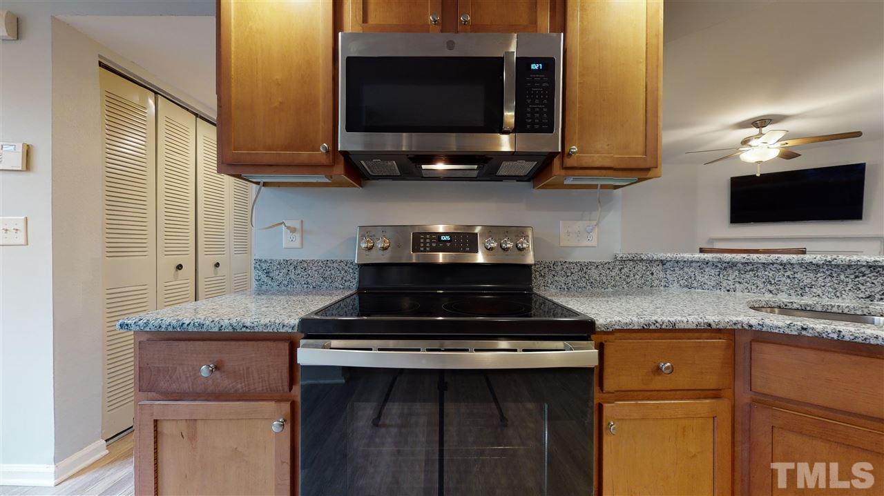 2453 Condor Court, Unit 2453 Raleigh, NC 27615 - Photo 8 of 26 a kitchen with stainless steel appliances granite countertop a stove a microwave and oven