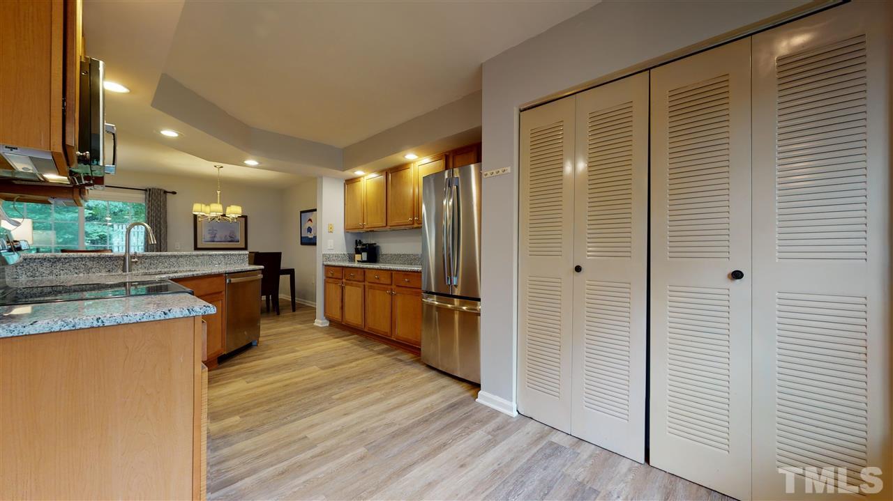 2453 Condor Court, Unit 2453 Raleigh, NC 27615 - Photo 10 of 26 a kitchen with stainless steel appliances granite countertop a refrigerator a oven a sink and dishwasher with wooden floor
