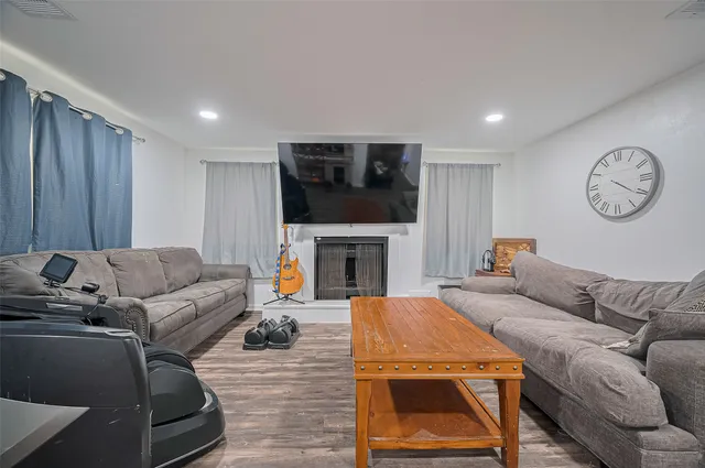 a living room with furniture a fireplace and a flat screen tv