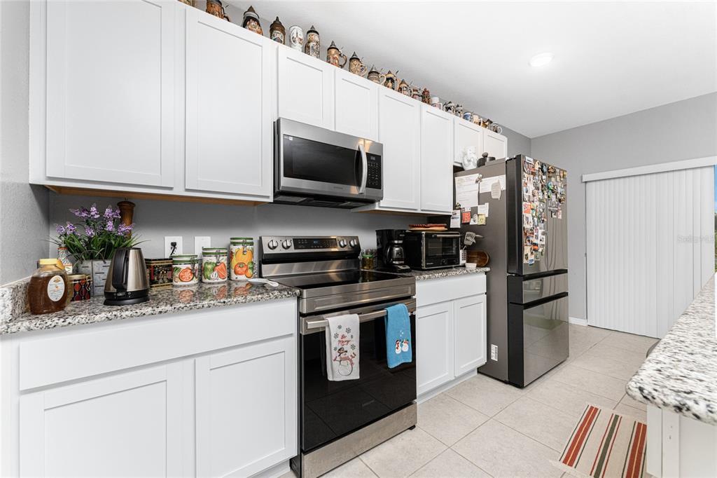 475 Posadas Circle Punta Gorda, FL 33983 - Photo 13 of 54 a kitchen with stainless steel appliances granite countertop a refrigerator a stove a sink and white cabinets