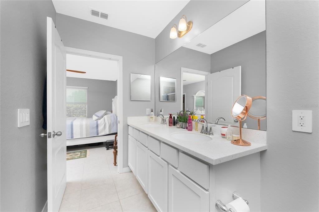 475 Posadas Circle Punta Gorda, FL 33983 - Photo 23 of 54 a en suite bathroom with a double vanity sink and a mirror