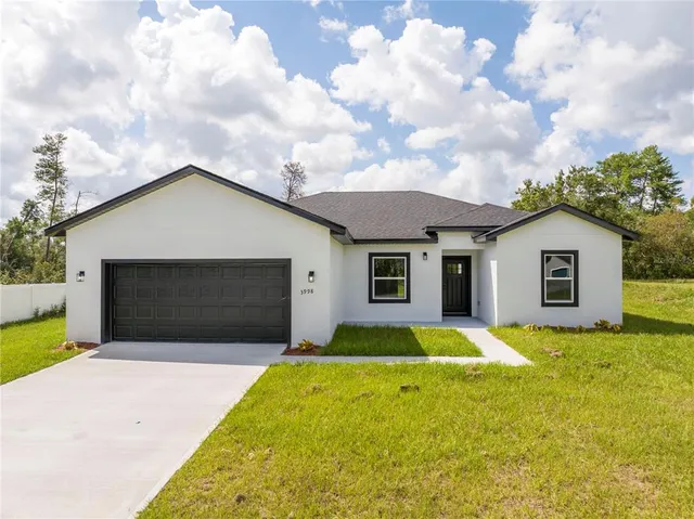 a front view of a house with yard and garage