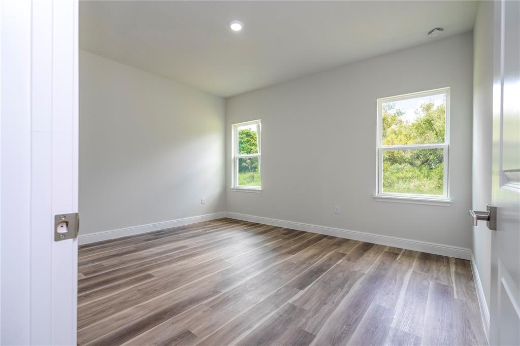 3998 Southwest 157th Place Road Ocala, FL 34473 - Photo 63 of 88 an empty room with wooden floor and windows