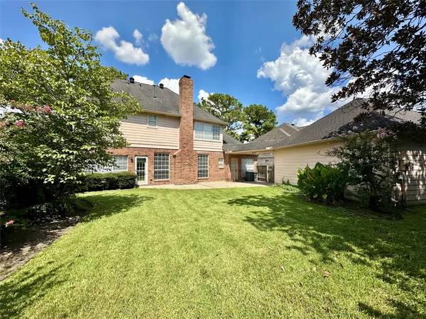 a view of a house with a big yard and large trees