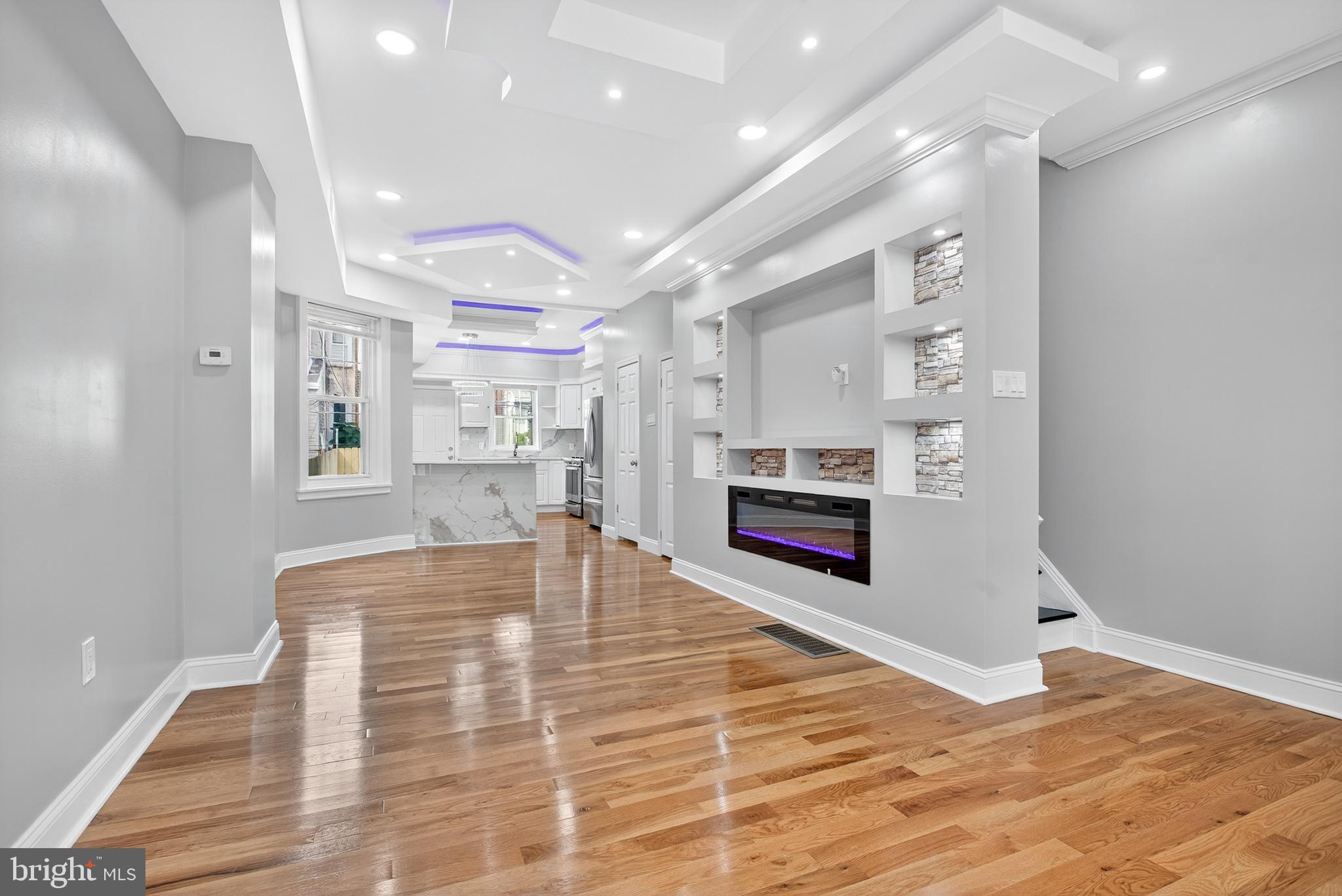 6351 Reedland Street Philadelphia, PA 19142 - Photo 6 of 30 a large white kitchen with cabinets and wooden floor