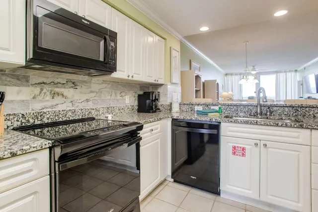 a kitchen with stainless steel appliances granite countertop a stove microwave and cabinets