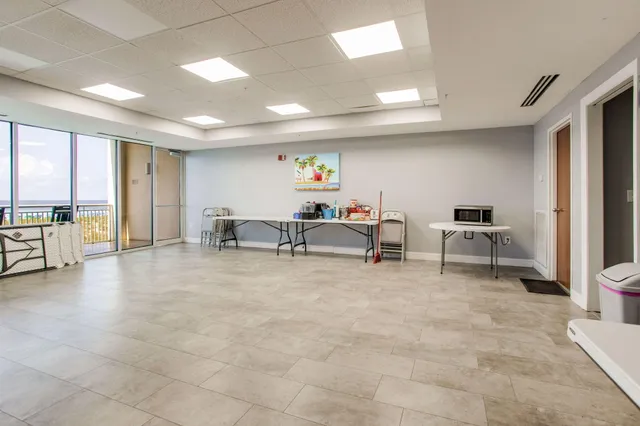 a living room with furniture and a gym machine with stainless steel appliances