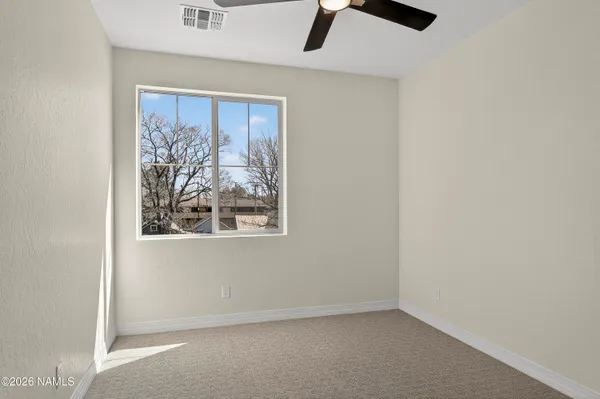 an empty room with a window and a ceiling fan