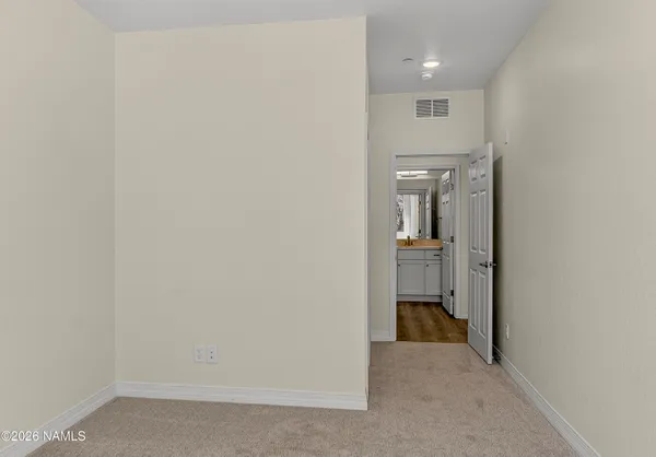 a view of a hallway with a livingroom and a bathroom