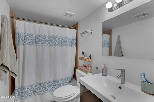 a bedroom with a bed and a chandelier fan