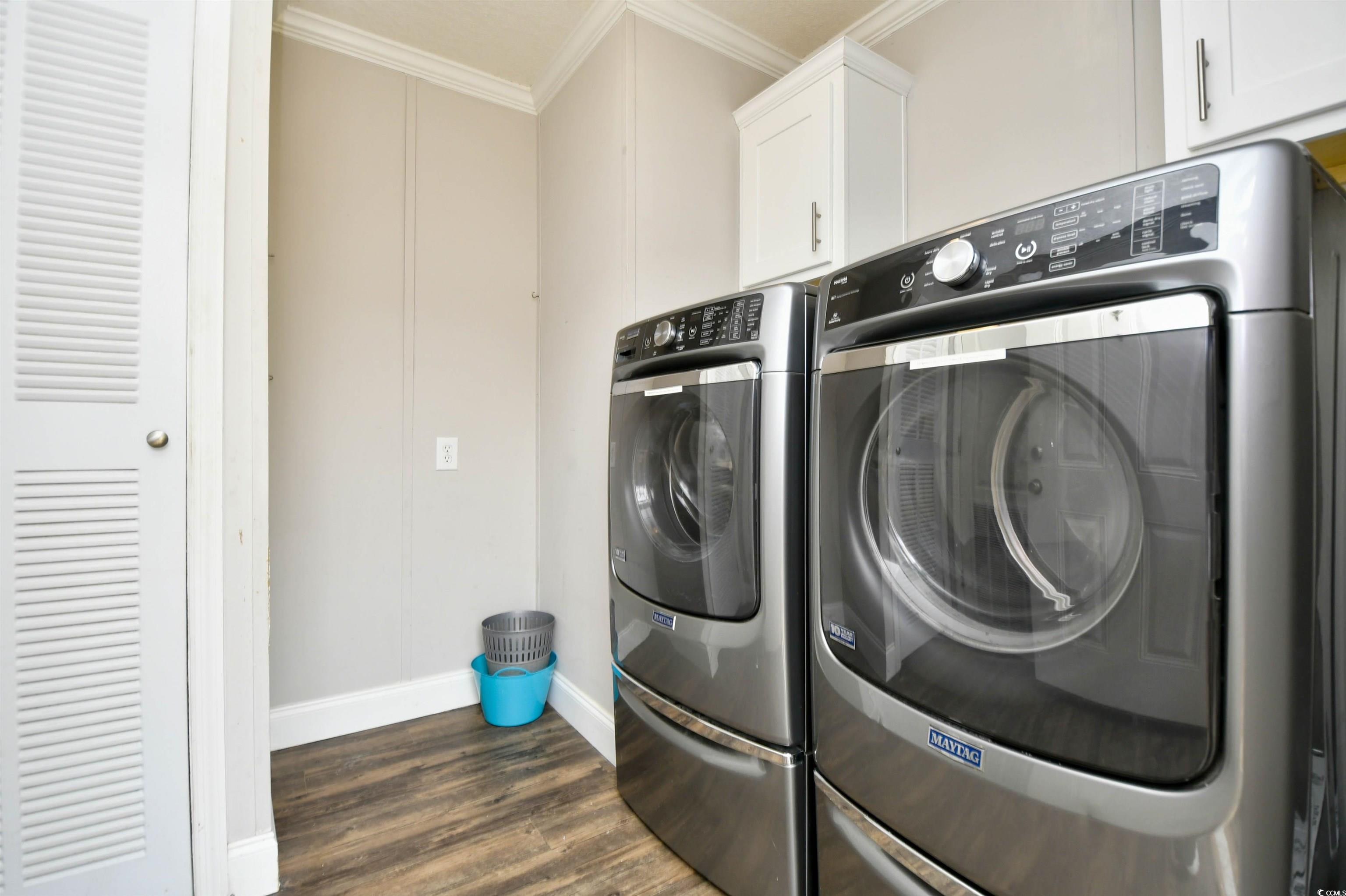596 Trizzie Trail Murrells Inlet, SC 29576 - Photo 15 of 21 Washroom featuring separate washer and dryer, dark wood-style floors, cabinet space, and ornamental molding