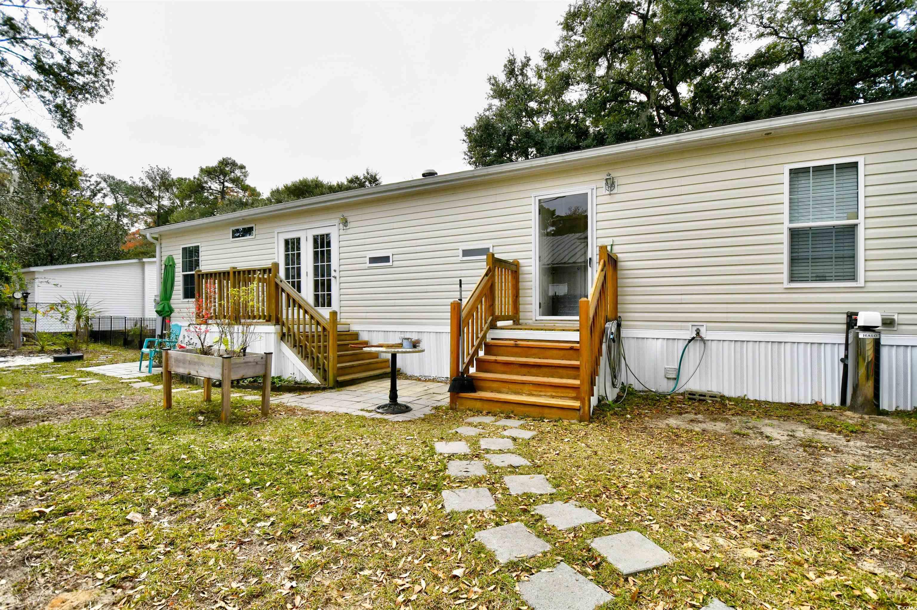 596 Trizzie Trail Murrells Inlet, SC 29576 - Photo 17 of 21 Rear view of house featuring a lawn and a patio area