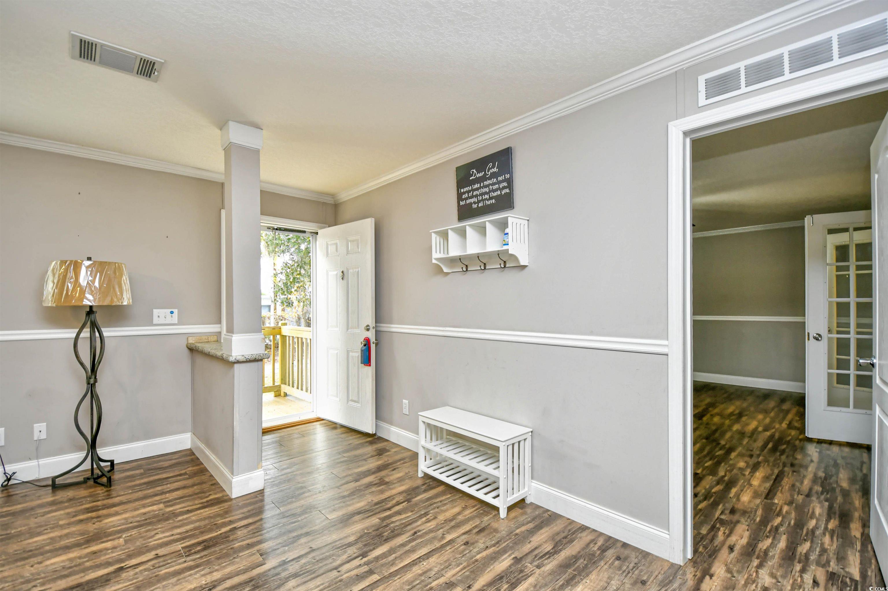 596 Trizzie Trail Murrells Inlet, SC 29576 - Photo 2 of 21 Foyer featuring ornamental molding, dark wood finished floors, decorative columns, and a textured ceiling
