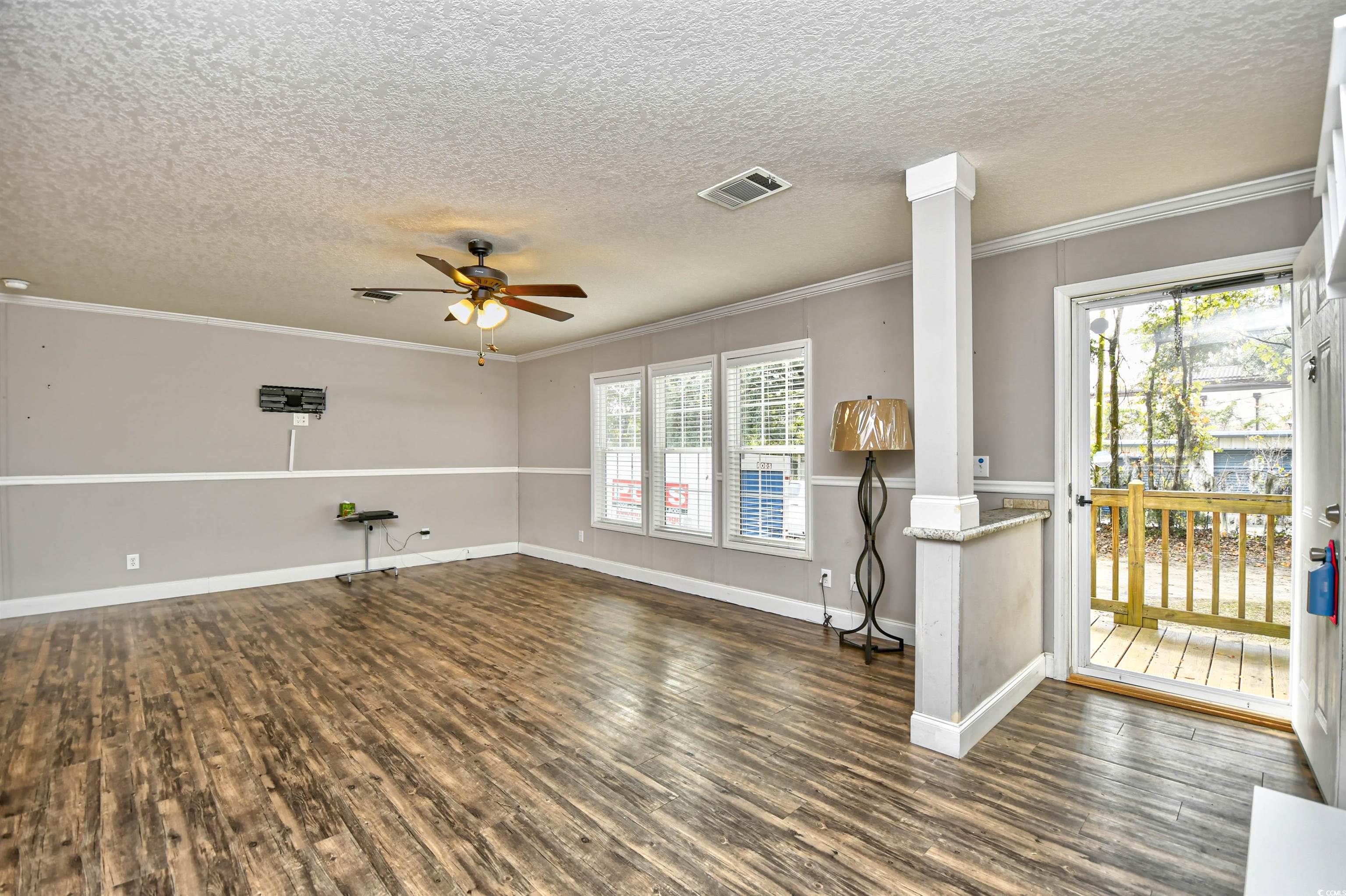 596 Trizzie Trail Murrells Inlet, SC 29576 - Photo 3 of 21 Living room with a textured ceiling, ornamental molding, a ceiling fan, and wood-style floors