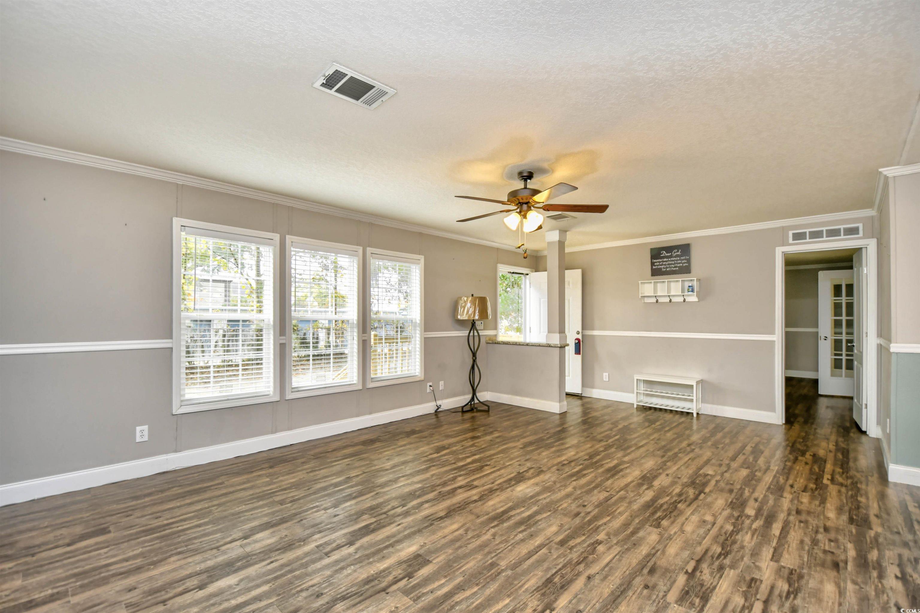 596 Trizzie Trail Murrells Inlet, SC 29576 - Photo 5 of 21 Living room with wood-style floors, a textured ceiling, ornamental molding, and ceiling fan