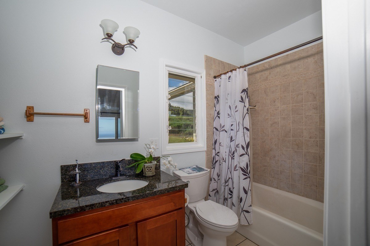 5495 A Puulima Road, Unit D Kalaheo, HI 96741 - Photo 16 of 24 a bathroom with a granite countertop sink a toilet and shower