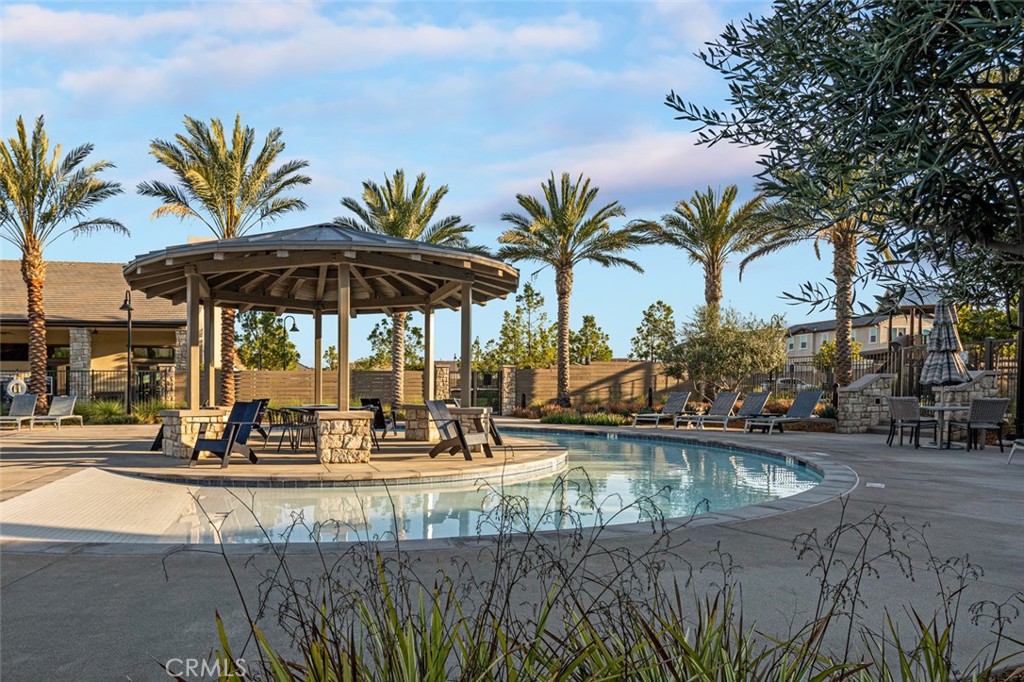 39504 Caladium Drive Temecula, CA 92591 - Photo 32 of 38 a view of a swimming pool with a lawn chairs under an umbrella
